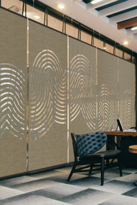 Acoustic panels with creative swirls are suspended in a room to create a divider of space.